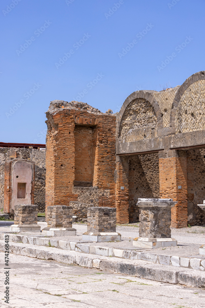 Obraz premium Ruins of an ancient city destroyed by the eruption of the volcano Vesuvius in 79 AD near Naples, Pompeii, Italy. Portico in front of the entrance to the Macellum