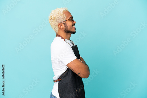 Restaurant Colombian waiter man isolated on blue background in lateral position photo