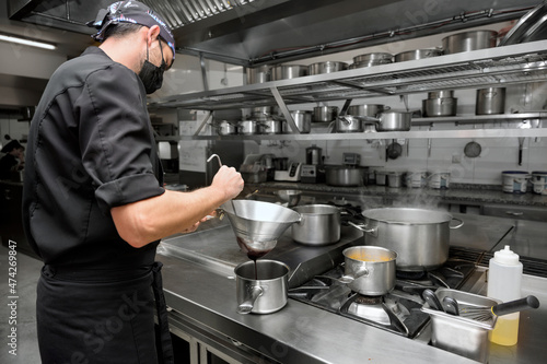 Chef cooking in modern industrial kitchen. High quality photo