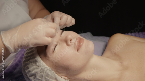 Woman receiving facial massage in spa salon on massage table. Wellness body and skin care  face beauty treatment  receiving rejuvenation procedure