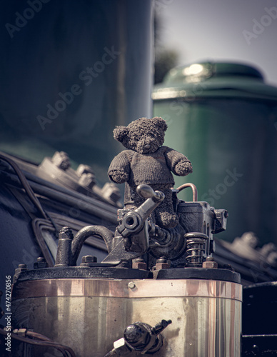 blackened teddy bear on top of steam train part