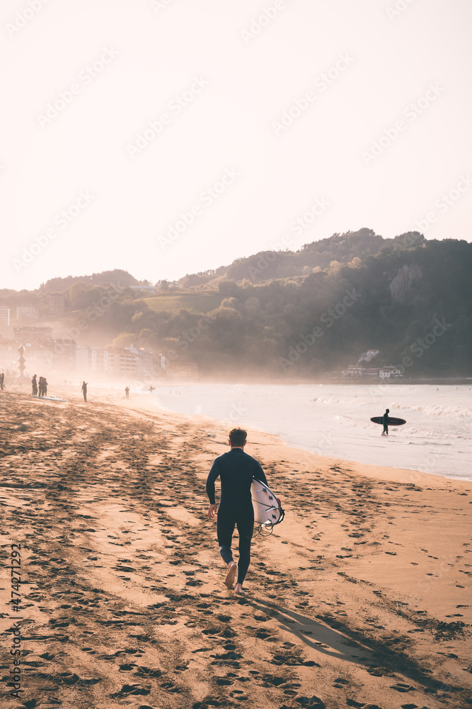 Fototapeta premium Surfer running to water - Man back portrait surf