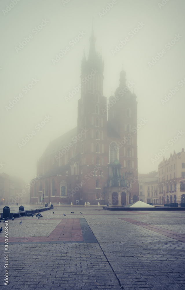Fototapeta premium St Mary's church on Krakow Main Square in the thick fog, Poland.