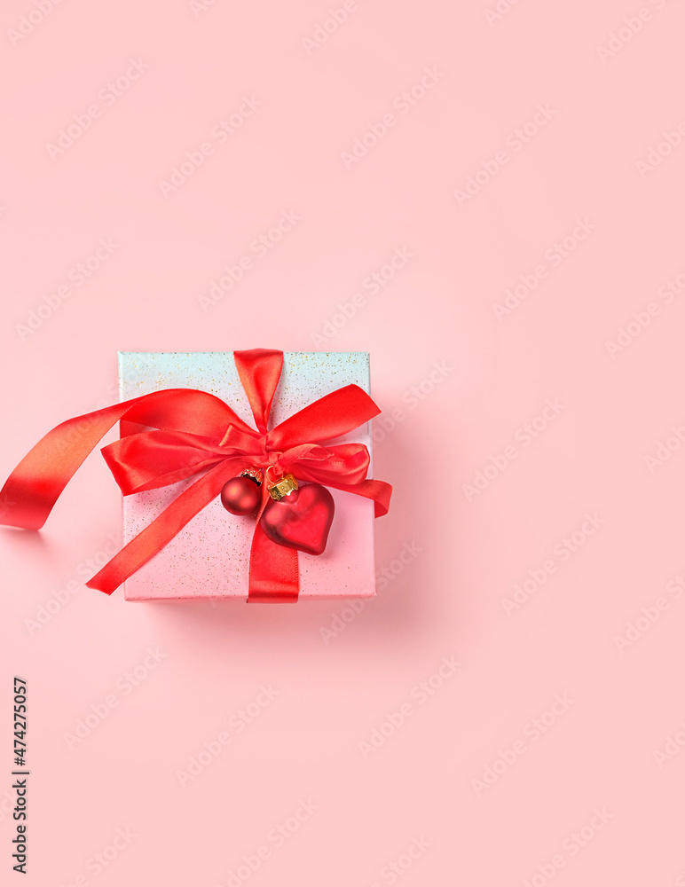 gift box with red satin ribbon and decor heart on pink pastel background. Valentine's day or Christmas holidays concept. romantic present concept. flat lay. copy space gift box with red satin ribbon and decor heart on pink pastel background. Valentine's day or Christmas holidays concept. romantic present concept. flat lay. copy space