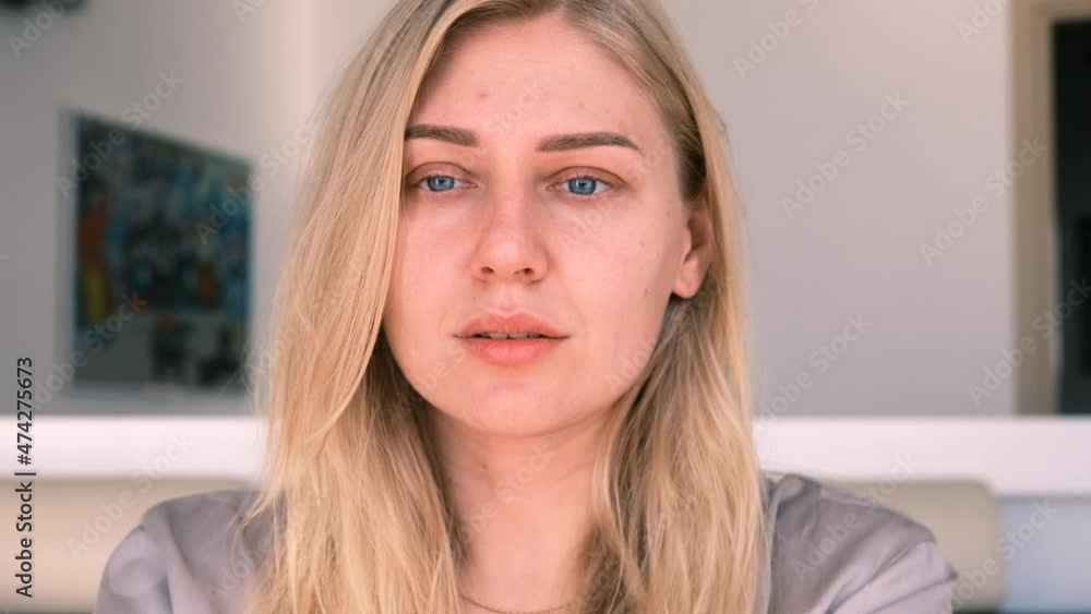 Young alluring blonde woman with blue eyes looks peacefully into the camera, 4k, slow motion Young alluring blonde woman with blue eyes looks peacefully into the camera, 4k, slow motion
