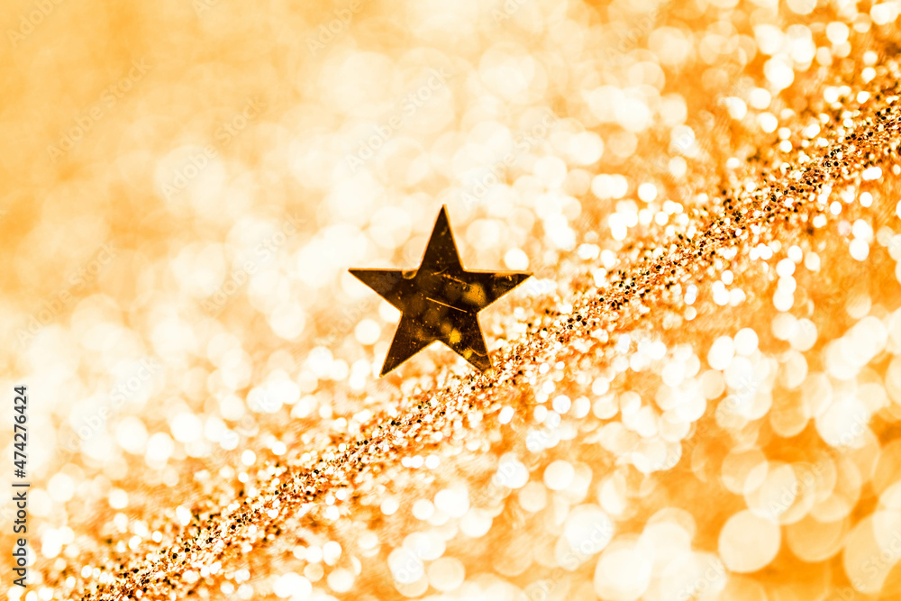 Golden stars on a gold background, Shiny sparkling gold background with copy space.
