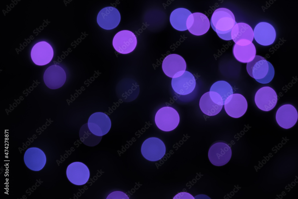 Defocused bokeh lights on black background, an abstract naturally blurred backdrop for Christmas eve or birthday party. Festive light texture. Violet blue garland in blur. Overlay effect for design Defocused bokeh lights on black background, an abstract naturally blurred backdrop for Christmas eve or birthday party. Festive light texture. Violet blue garland in blur. Overlay effect for design