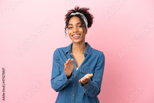 Young latin woman isolated on pink background applauding after presentation in a conference photo