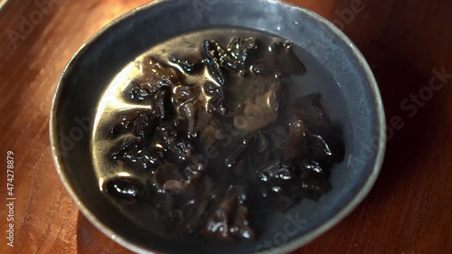 Dried Mushrooms Soaked In Water. Time Lapse. photo