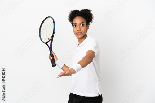 Young latin woman isolated on white background playing tennis © luismolinero