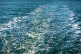 View of blue ocean water waking behind a ferry in the Pacific Northwest