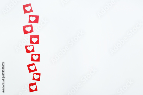 red squares with cut-out hearts on a white background with space for text photo