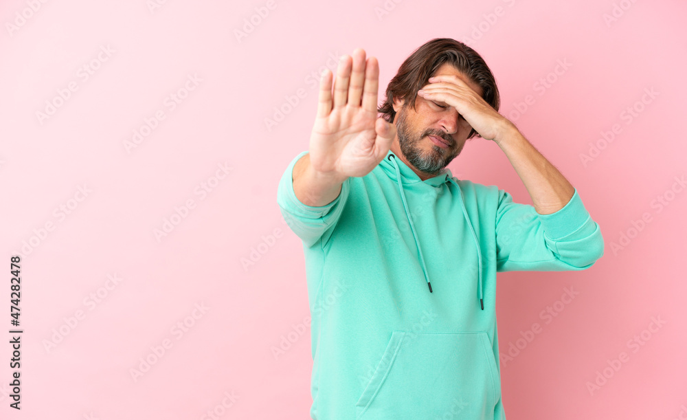 Senior dutch man isolated on pink background making stop gesture and covering face Senior dutch man isolated on pink background making stop gesture and covering face