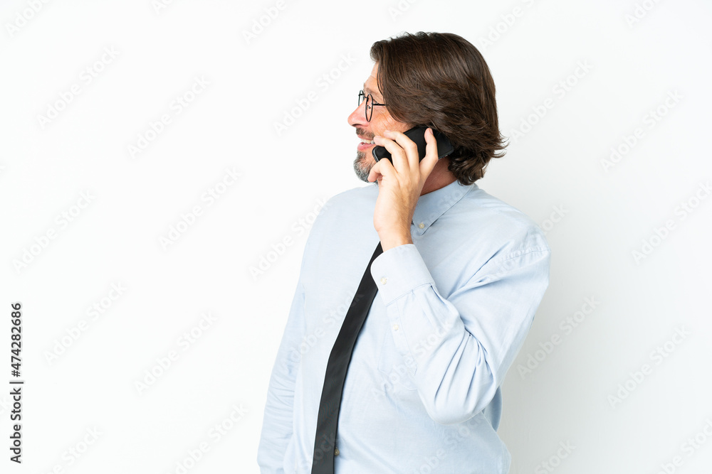 Senior dutch business man isolated on white background keeping a conversation with the mobile phone with someone Senior dutch business man isolated on white background keeping a conversation with the mobile phone with someone