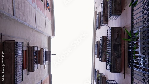 Cityscape of old narrow european alley between residential housing. Historic spanish center of Madrid or Seville. Medieval architecture. Steadicam shot