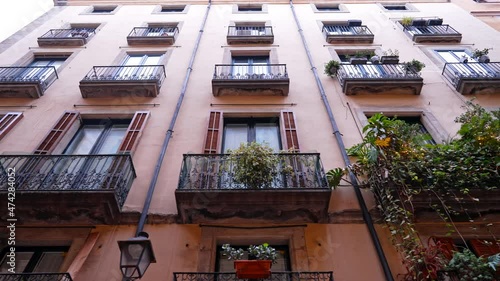 Steadicam shot: house exterior with balconies in Madrid. Facades of medieval apartment buildings in narrow street of Europe. Traveling concept. 