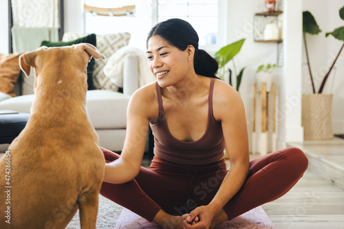 Woman Exercising By Dog At Home