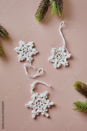 Sustainable and eco-friendly Christmas deco, handmade crochet cotton snowflakes, flatlay on beige photo