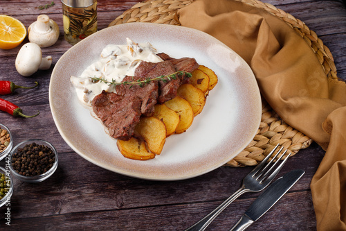 Thick juicy portions of grilled beef fillet with mushroom sauce served with thyme potatoes