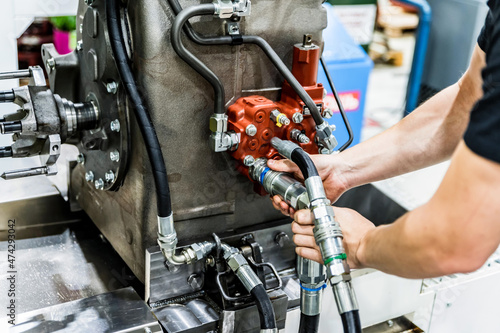 Industrial worker assembles agricultural equipment at plant