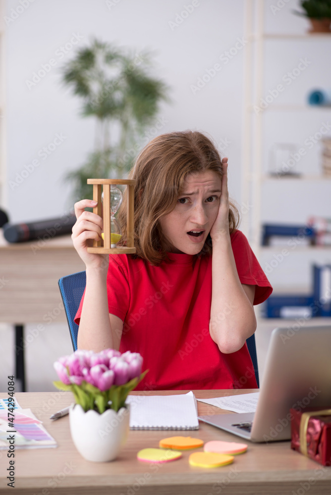 Young female designer in time management concept Young female designer in time management concept