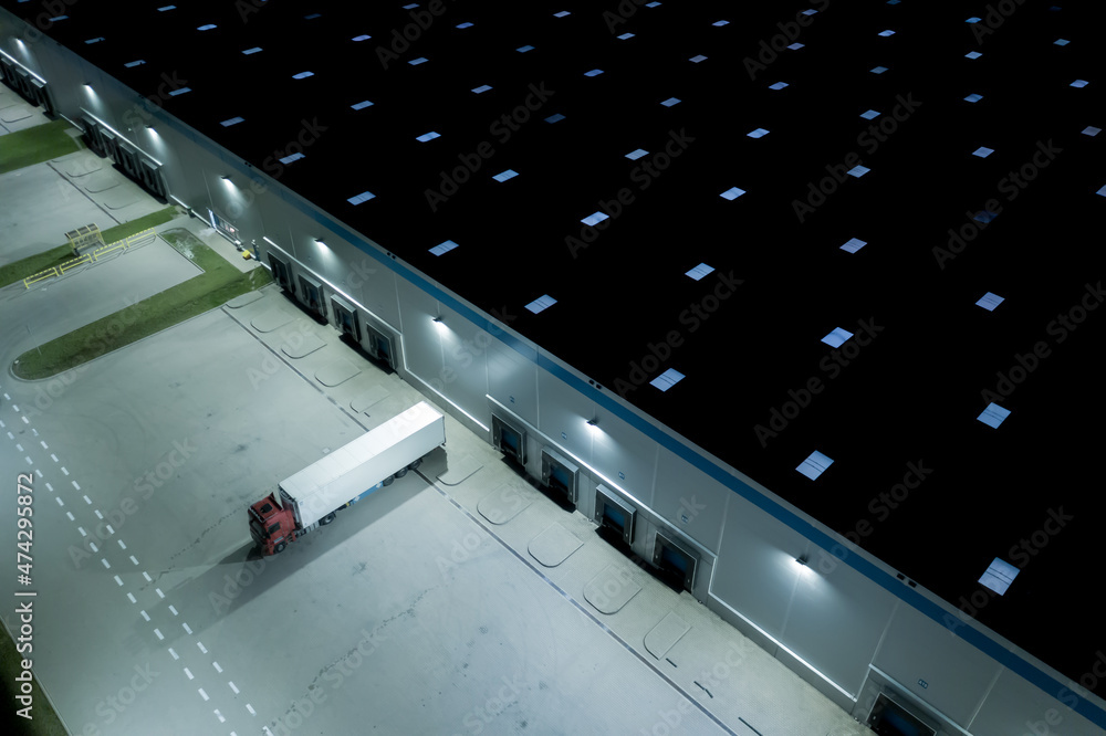 Night Aerial top view of truck and cargo trailer unloading in lo Night Aerial top view of truck and cargo trailer unloading in lo