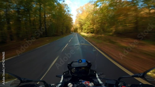 A scenic motorcycle ride at fall, in the French forest of Rambouillet in October, on a beautiful golden road photo