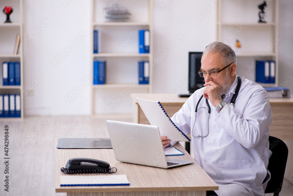Old male doctor working in the clinic Old male doctor working in the clinic