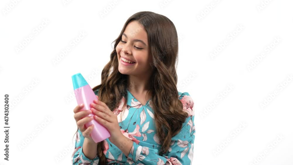 cheerful kid girl with curly hair offer to wash hair with teen shampoo product, presenting product cheerful kid girl with curly hair offer to wash hair with teen shampoo product, presenting product