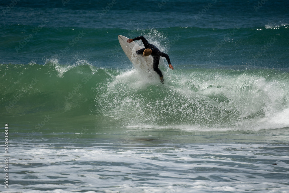 male surfer catching waves surfing at south coast beach on a bright warm sunny day on clear blue water male surfer catching waves surfing at south coast beach on a bright warm sunny day on clear blue water