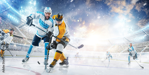 Sport. Hockey game in an open stadium. Two professional hockey player in action. Fight for the puck. Sports emotions. Ad