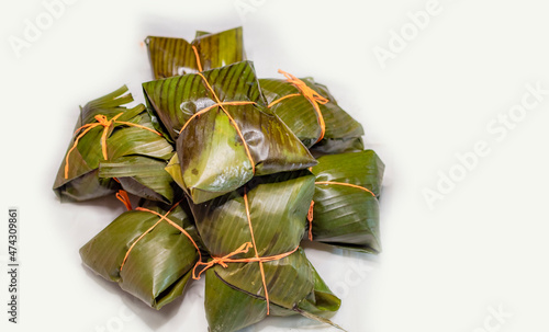 Close up of nacatamales with banana leaves on white background, Nacatamales heaped on white background photo
