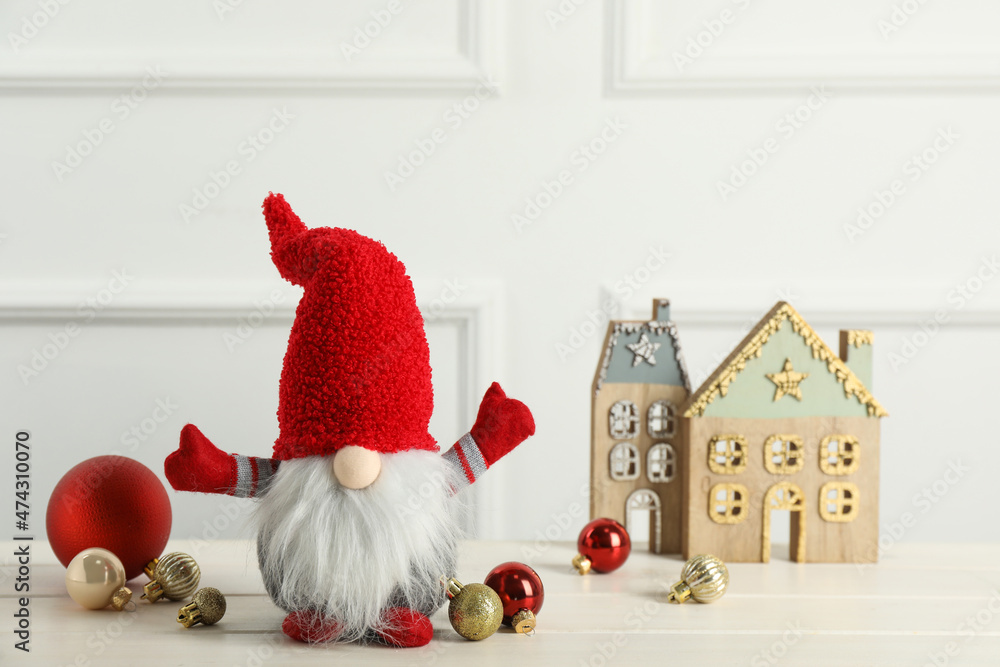 Obraz premium Cute Christmas gnome and festive decor on white wooden table