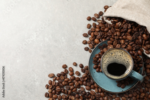 Fotografie Cup of aromatic hot coffee and beans on light grey table, flat lay