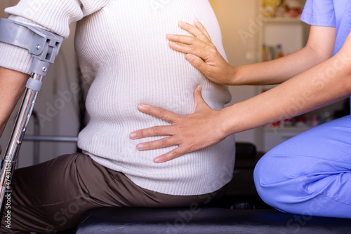 Physiotherapist doing treatment to senior woman patient in clinic ,Eldery women suffering from low-back lumbar pain,Physical therapy concept