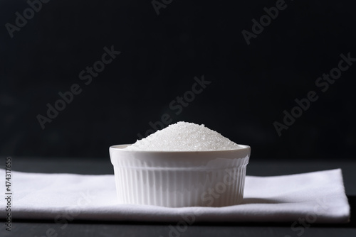 White granulated sugar on black background