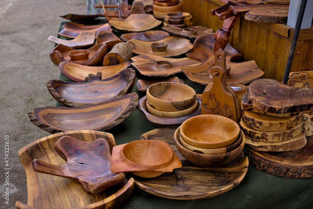 Open-air folk art fair: handicrafts made of wood, a set of dishes. Street trade in polished wood products in Kropivnitskiy, Ukraine.