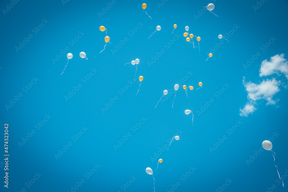 balloons yellow and white with helium on a blue sky background balloons yellow and white with helium on a blue sky background