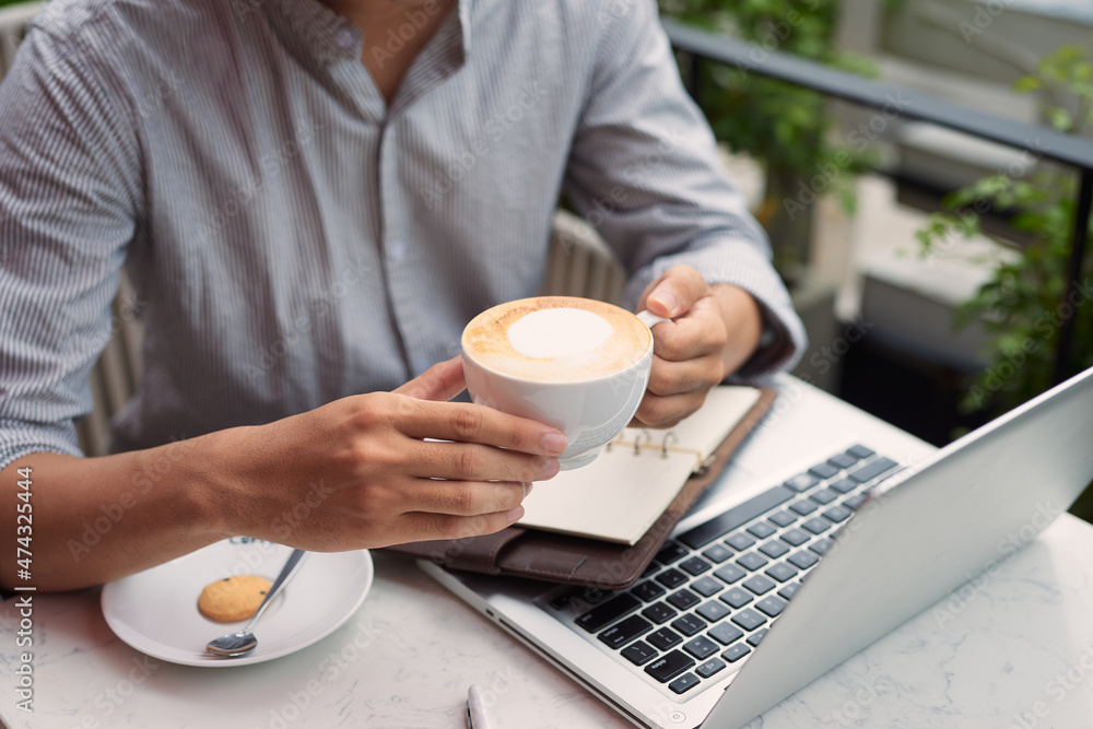 Young asian economist using laptop in coffee shop