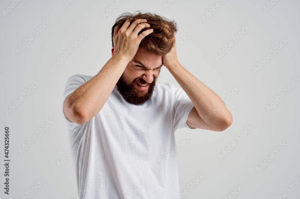 emotional man holding his head pain stress emotions light background