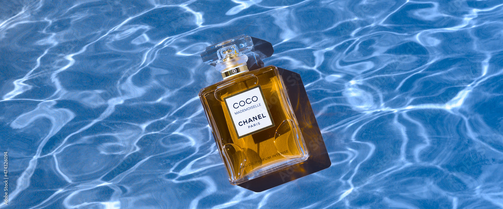 A bottle of Chanel perfume on the background of the texture of water, with  a beautiful shadow with highlights. Coco Chanel women's perfume series.  2020-07-05 Samara. foto de Stock | Adobe Stock