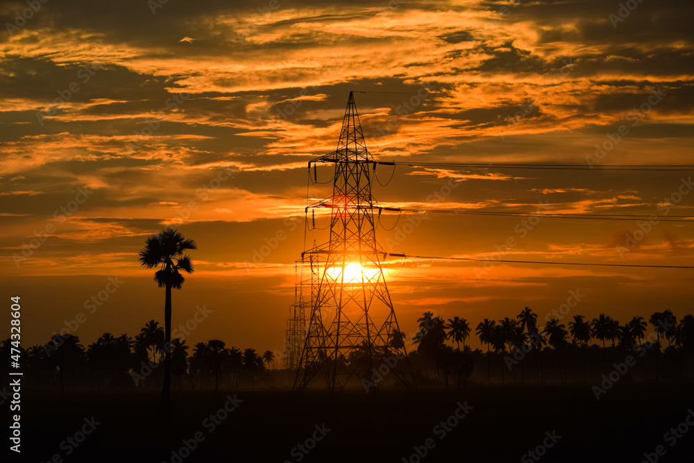 Electric pylon at sunset. High voltage power transmission towers on silhouette sunset background.