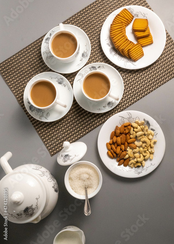 Tea time with Biscuits and dry fruits, White Plan Cashew, and Almonds.
seave in the white marble Tea set.  photo