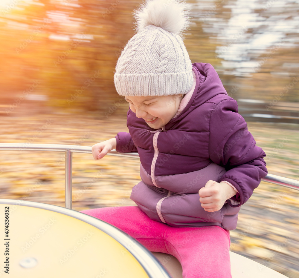 Young happy child merry go round outdoor in autumn Young happy child merry go round outdoor in autumn
