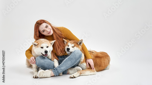 Canvas Print Smiling woman sitting and hugging Shiba Inu dogs