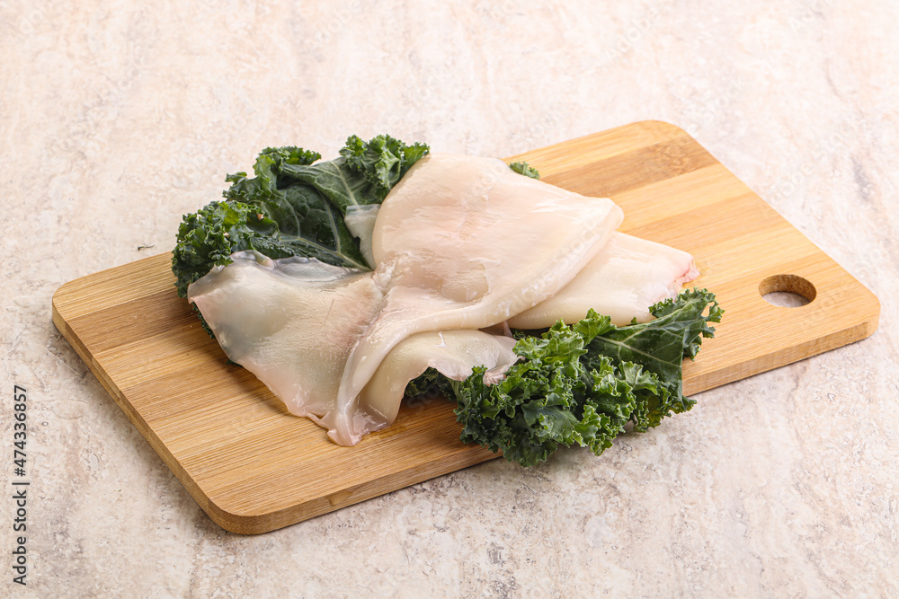 Raw squid over wooden board