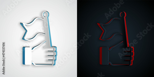 Paper cut Hand holding flag icon isolated on grey and black background. Victory, winning and conquer adversity concept. Paper art style. Vector