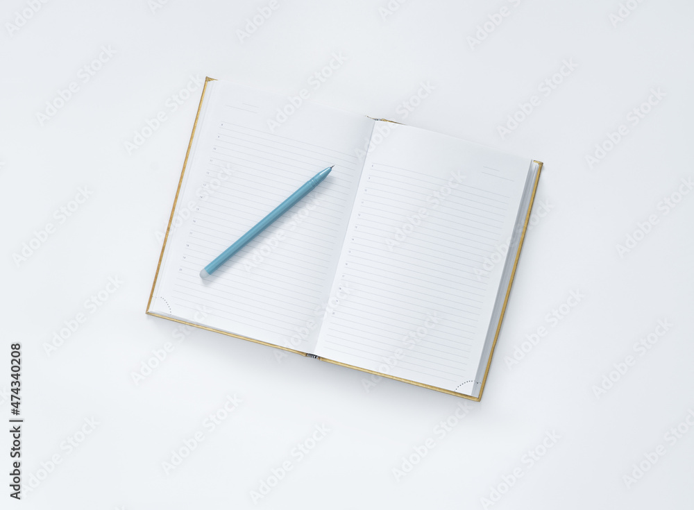 notebook and pen on a white background, top view. notebook and pen on a white background, top view.