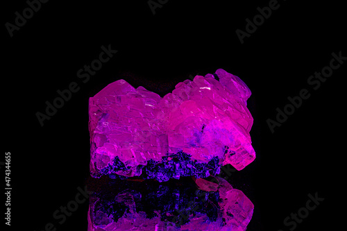 macro mineral stone calcite under ultraviolet light on a black background photo