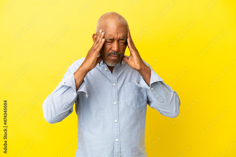 Cuban Senior isolated on yellow background with headache Cuban Senior isolated on yellow background with headache